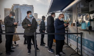 People queue to get a Covid-19 PCR test on 10 January in Beijing, China as the country locks down millions more residents in different cities.