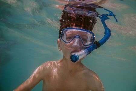 134609047-child-snorkeling-young-boy-wearing-diving-mask-and-snorkel-swimming-under-water-