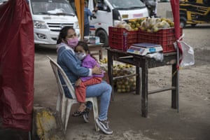 Maria Garcia embraces her daughter Sofia, while selling oranges on a street in Lima.